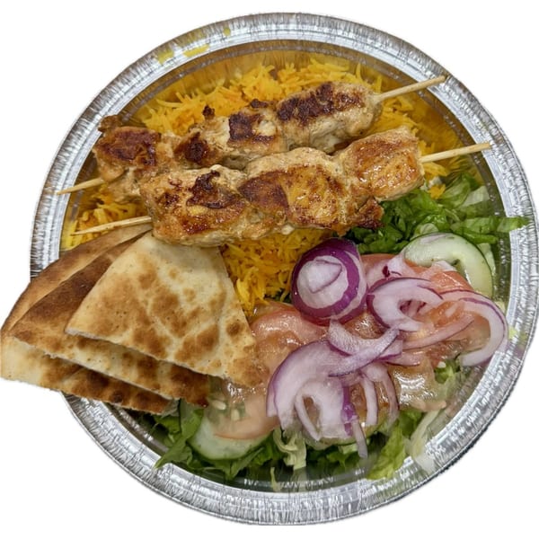 Halal chicken shish kebab with yellow rice, pita bread, and a fresh salad in a foil container.