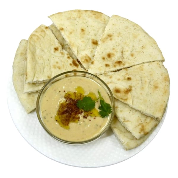 Hummus with olive oil, paprika, and cilantro, served with warm pita bread triangles on a white plate.