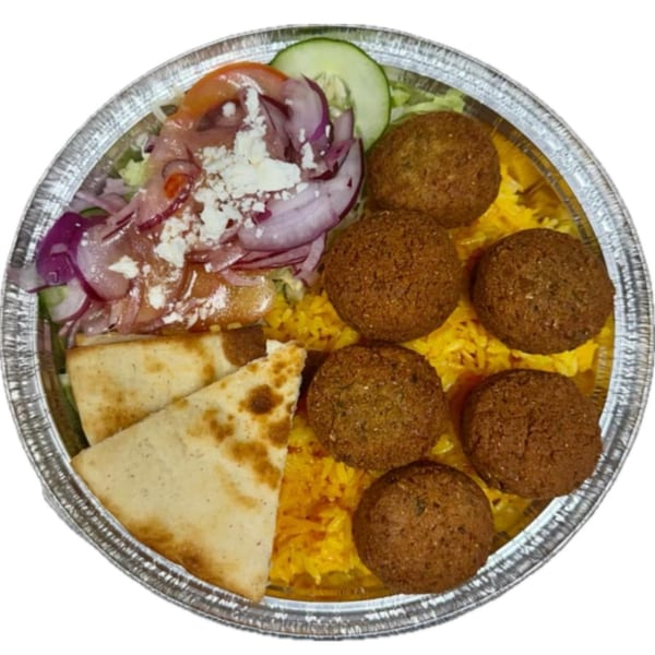 Halal falafel platter with yellow rice, salad, feta, red onions, and pita bread in a foil container.